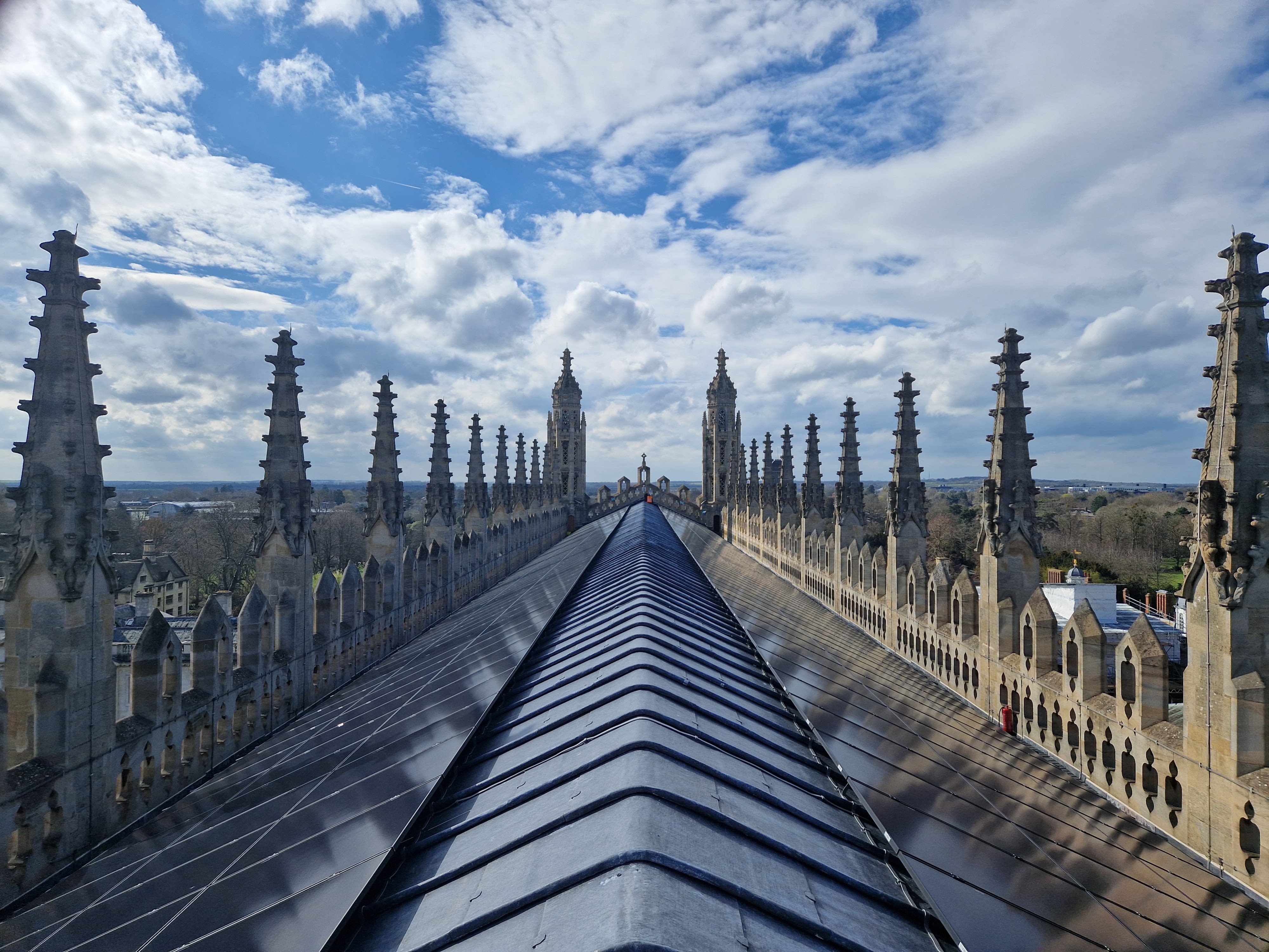 King's College Chapel roof; blue sky and white clouds are visible in the background and the lead roof is covered with photovoltaic panels.