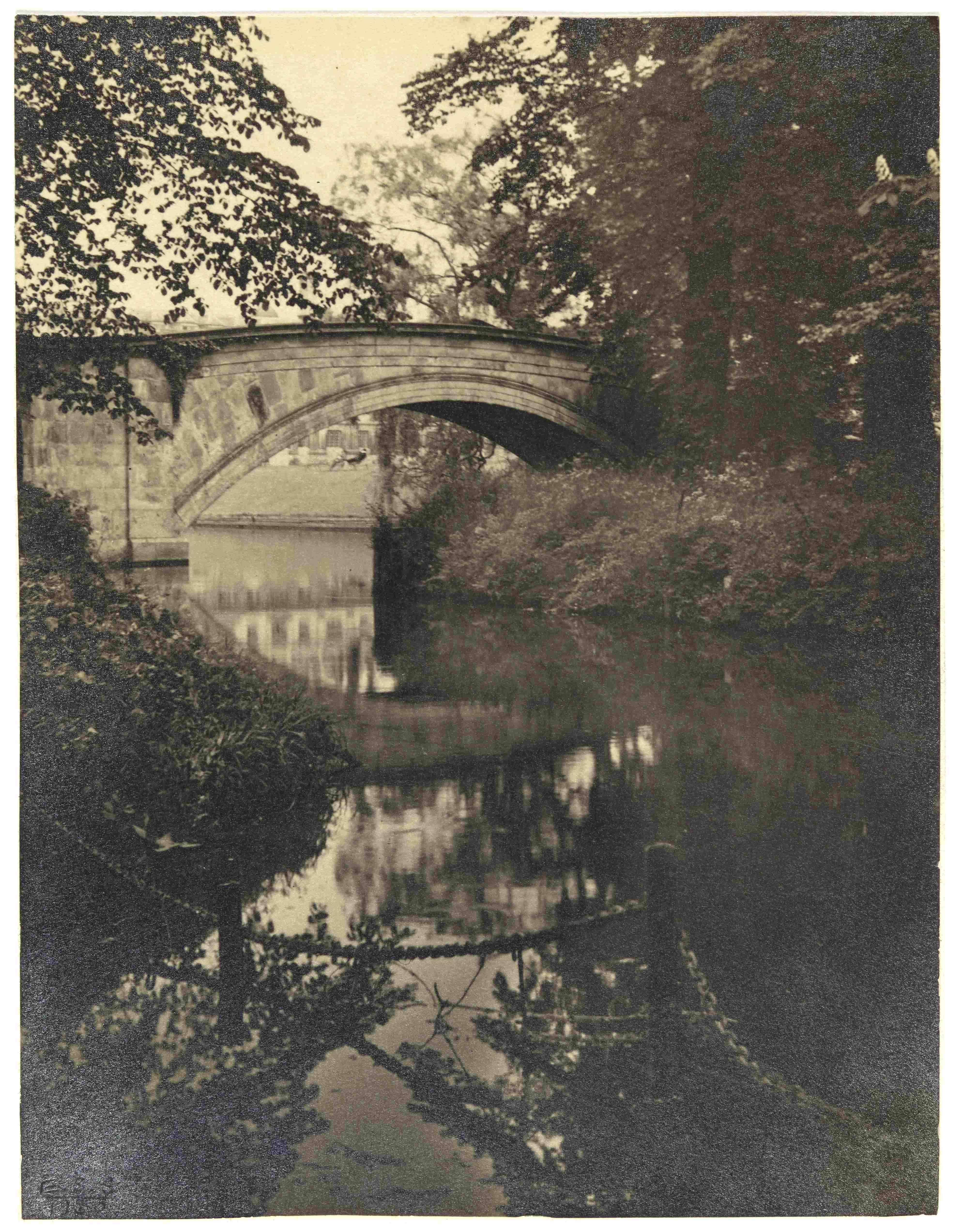 A black and white photo of the River Cam, a stone bridge and the beech tree at King's College