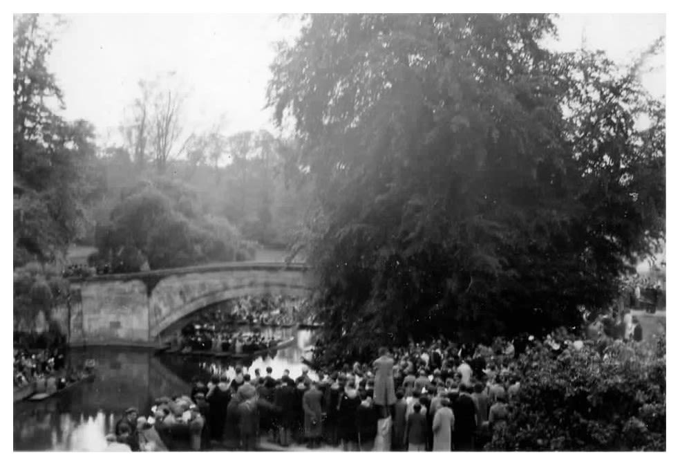 A black and white photo of a large gathering on the River Cam, King's College